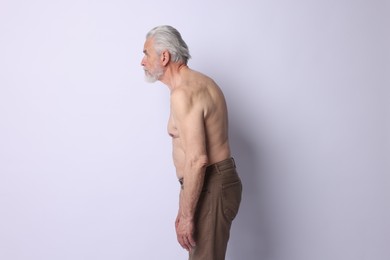 Photo of Senior man with bad posture on light background
