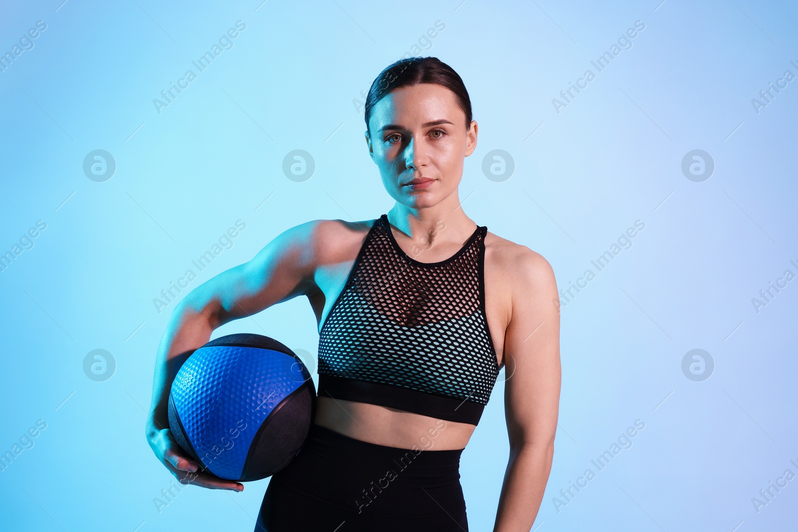 Woman with medicine ball on color background Photo of Woman with medicine ball on color background