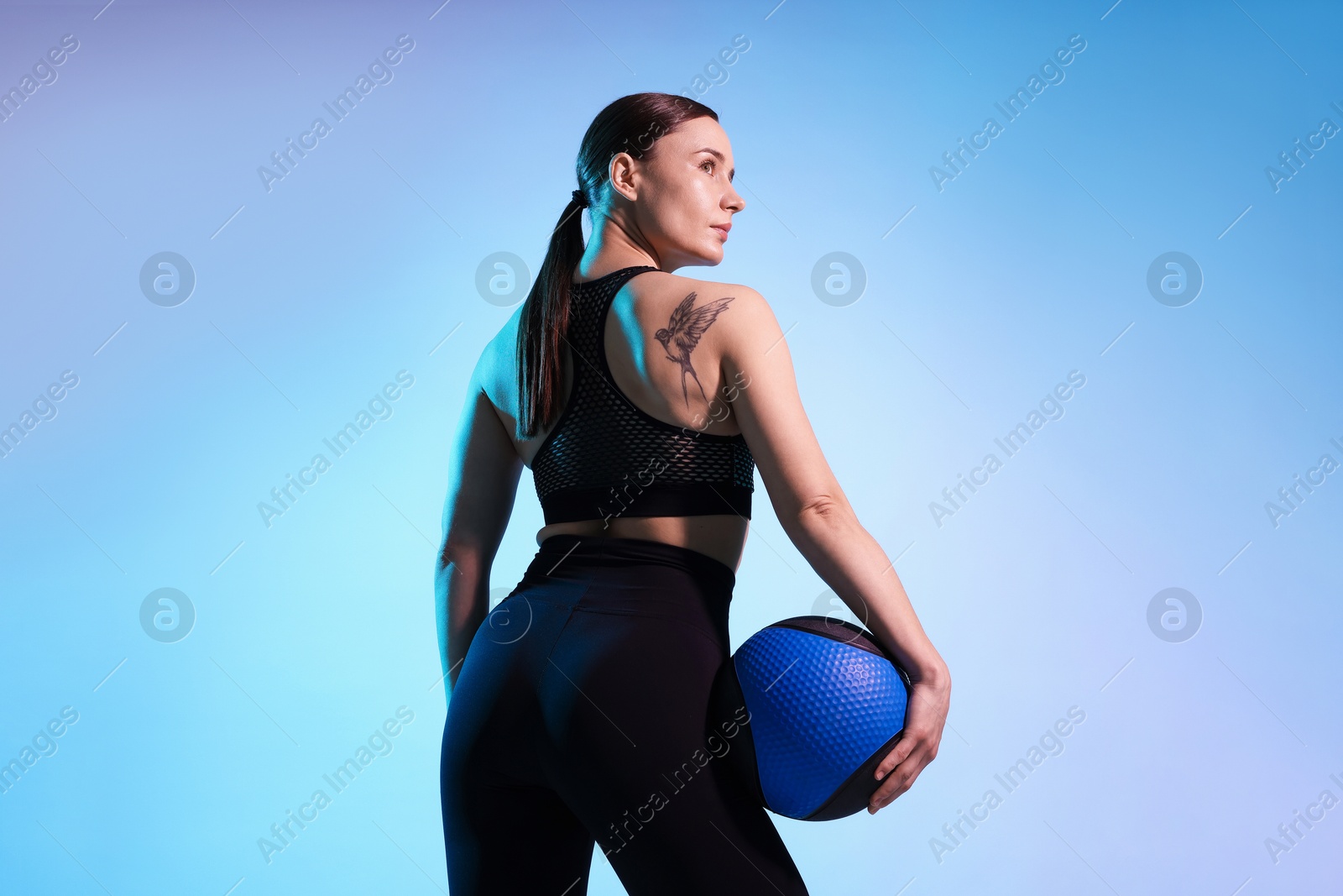 Woman with medicine ball on color background Photo of Woman with medicine ball on color background
