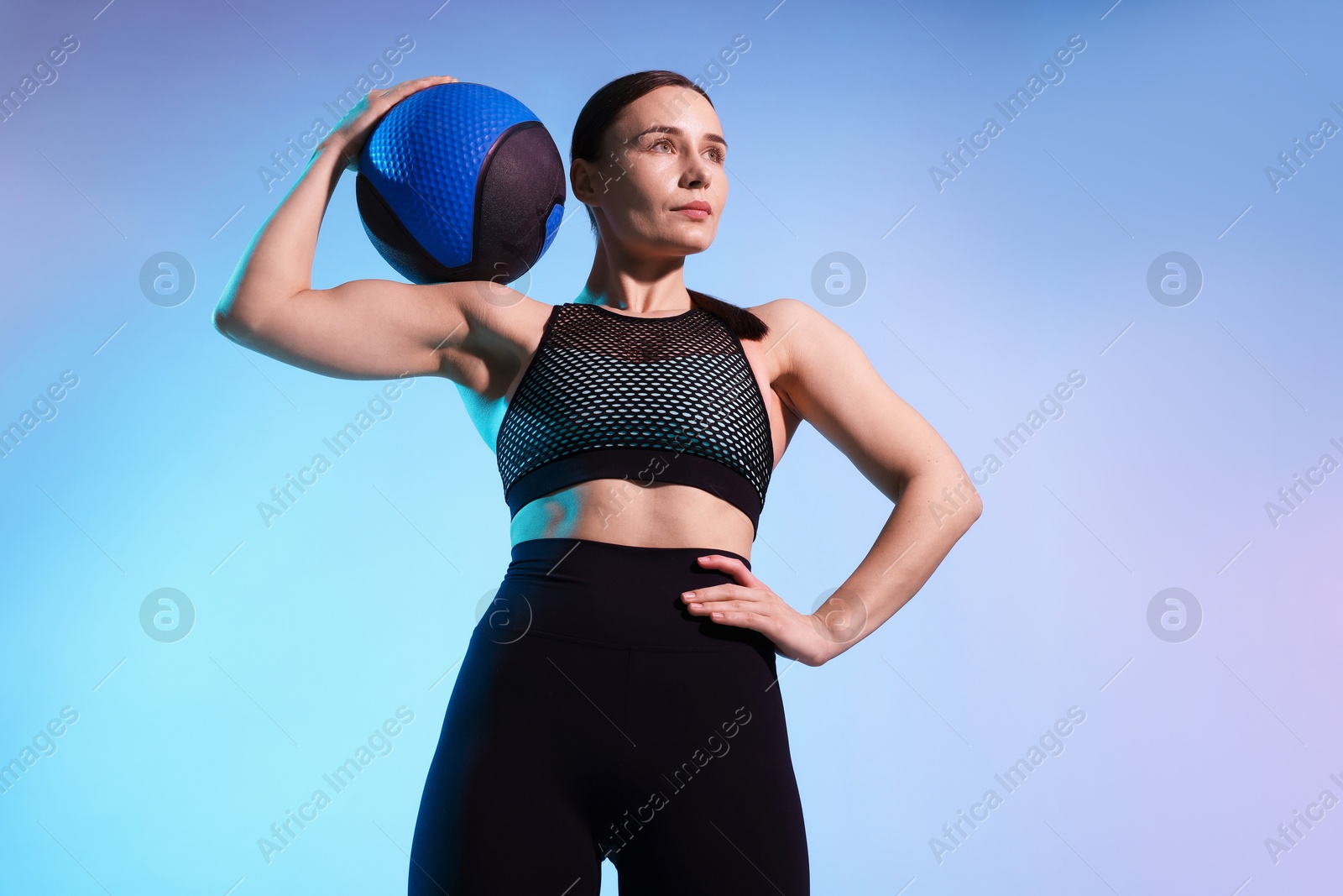 Woman with medicine ball on color background Photo of Woman with medicine ball on color background