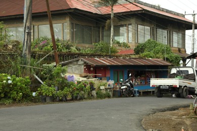 Photo of Bali, Indonesia - May 18, 2025: Transport parked near shop on street