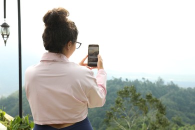 Photo of Bali, Indonesia - May 18, 2025: Woman taking picture of beautiful landscape. Space for text