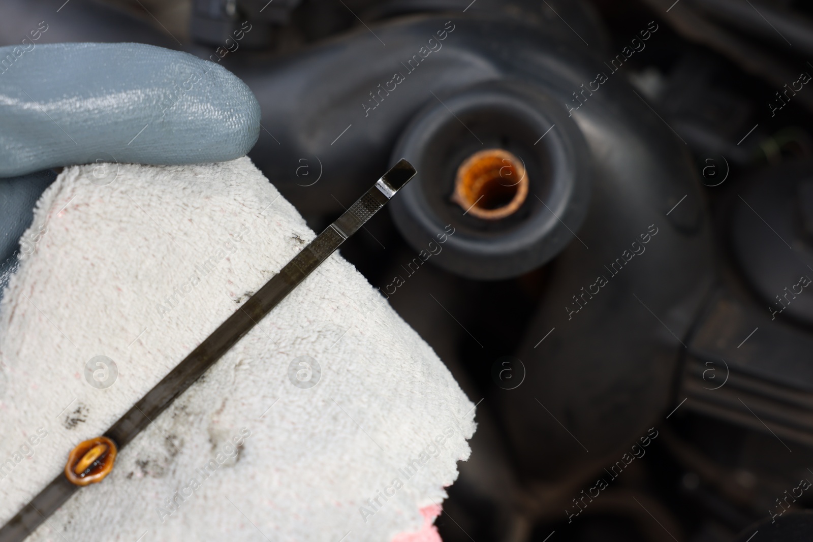 Worker checking motor oil level in car with dipstick, closeup Photo of Worker checking motor oil level in car with dipstick, closeup