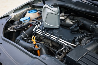 Photo of Checking motor oil level. Dipstick in car engine, closeup