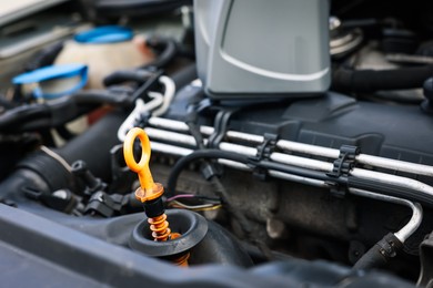 Photo of Checking motor oil level. Dipstick in car engine, closeup