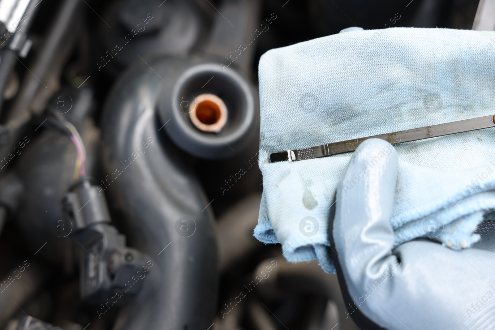 Worker checking motor oil level in car with dipstick, closeup Photo of Worker checking motor oil level in car with dipstick, closeup