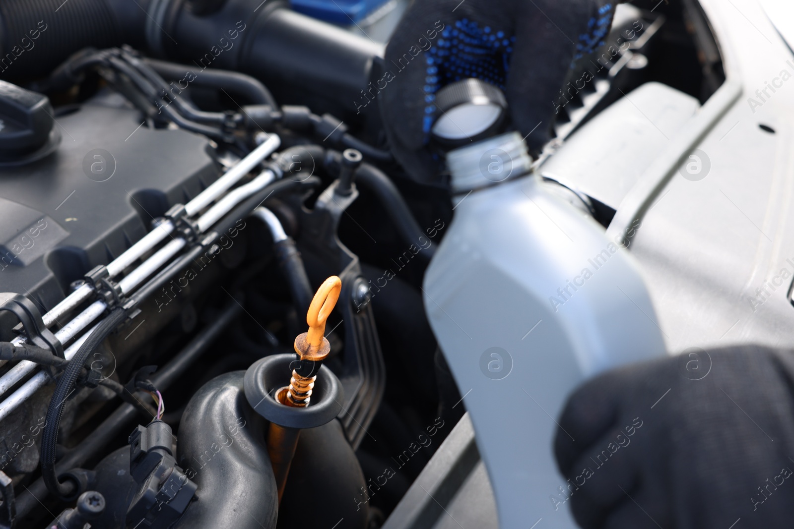 Worker checking motor oil level in car with dipstick, closeup Photo of Worker checking motor oil level in car with dipstick, closeup