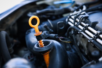 Photo of Checking motor oil level. Dipstick in car engine, closeup view