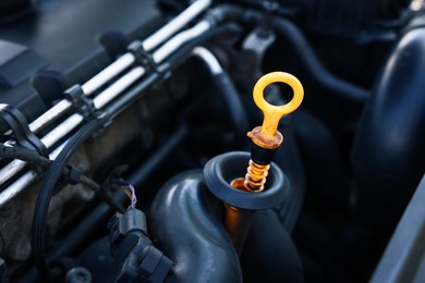 Photo of Checking motor oil level. Dipstick in car engine, closeup view