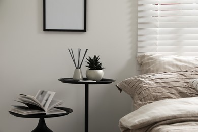 Photo of Comfortable bed with beautiful linens, nesting tables and decor in bedroom