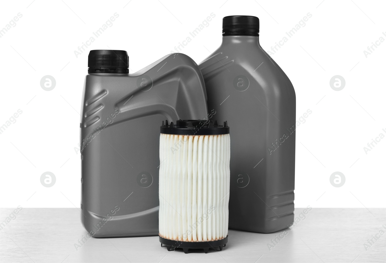 Motor oil in plastic canisters and filter isolated on white Photo of Motor oil in plastic canisters and filter isolated on white