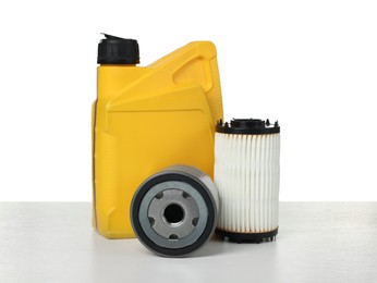 Photo of Motor oil in yellow canister and filters isolated on white