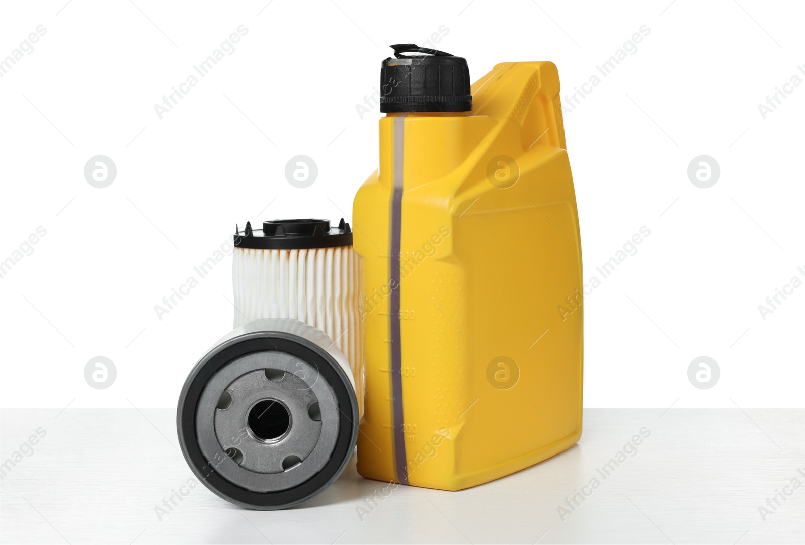 Photo of Motor oil in yellow canister and filters isolated on white