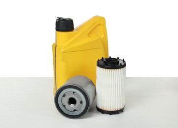 Photo of Motor oil in yellow canister and filters isolated on white