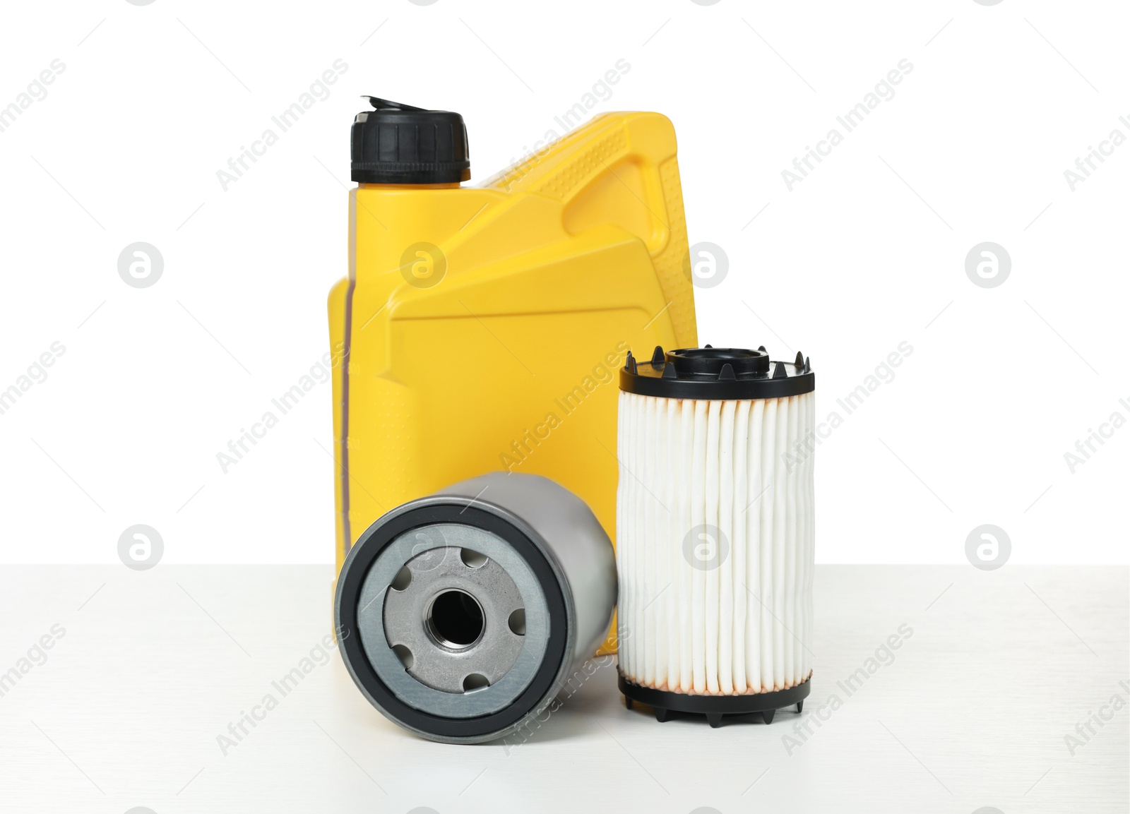 Photo of Motor oil in yellow canister and filters isolated on white