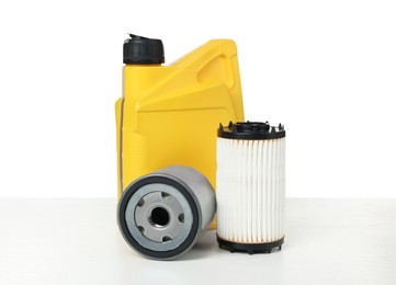 Photo of Motor oil in yellow canister and filters isolated on white
