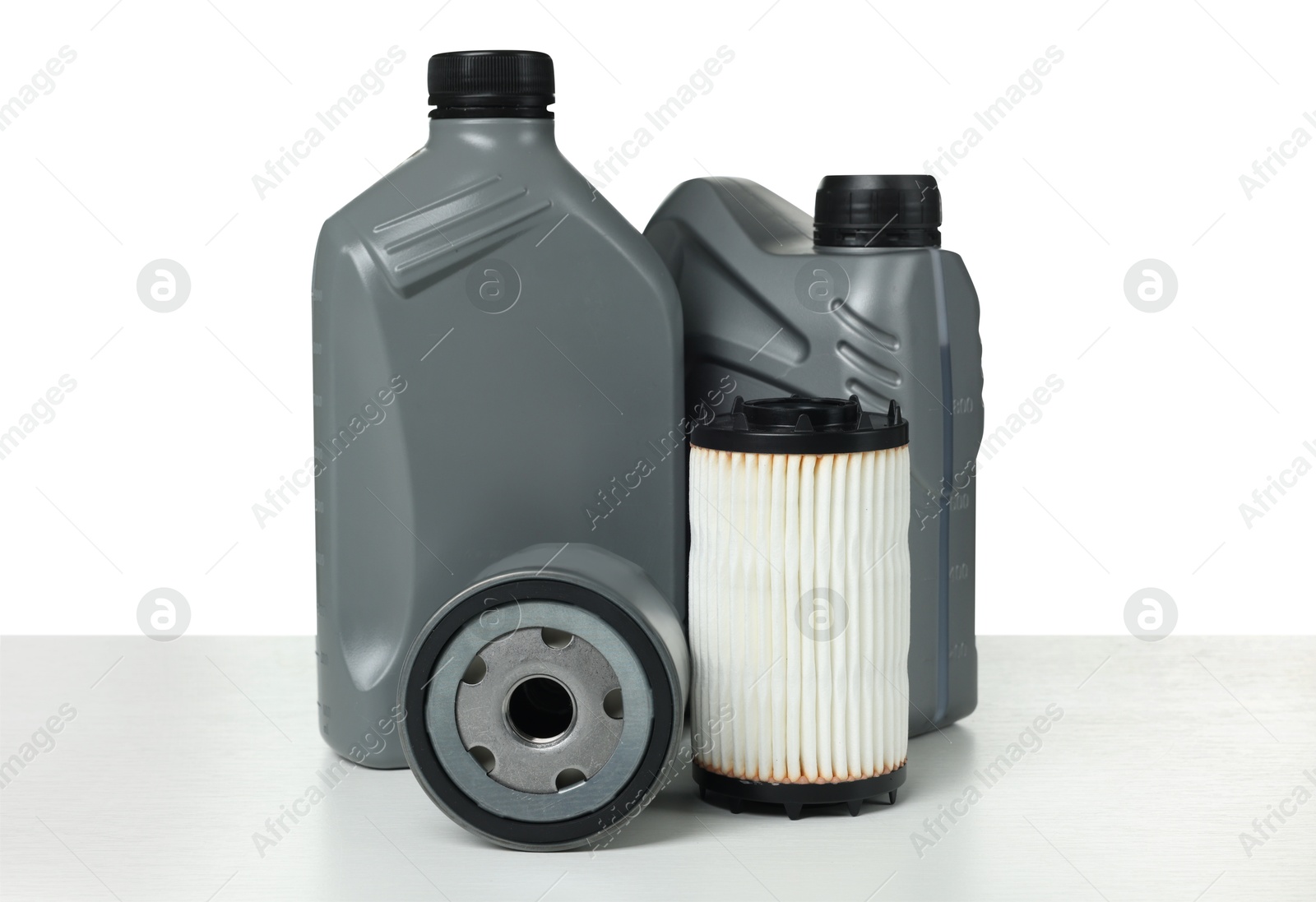 Motor oil in plastic canisters and filters isolated on white Photo of Motor oil in plastic canisters and filters isolated on white