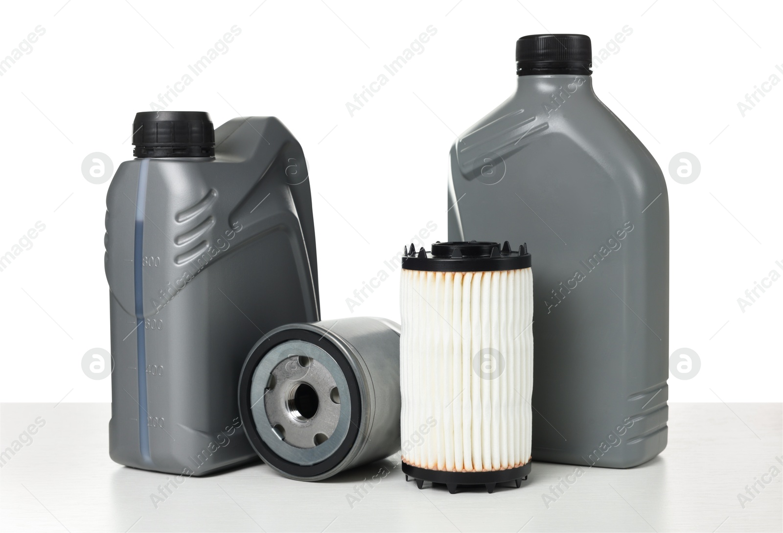 Motor oil in plastic canisters and filters isolated on white Photo of Motor oil in plastic canisters and filters isolated on white
