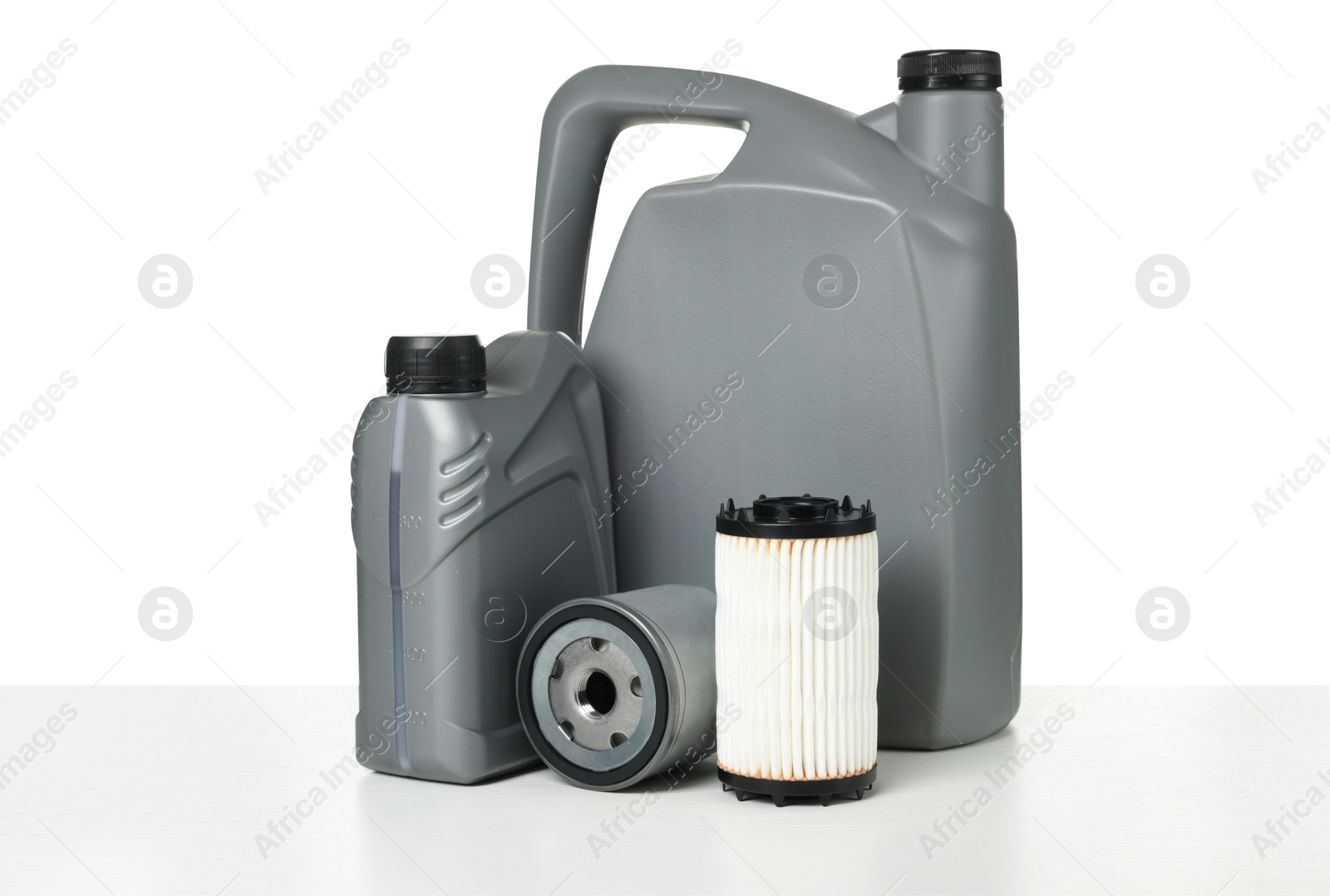 Motor oil in plastic canisters and filters isolated on white Photo of Motor oil in plastic canisters and filters isolated on white