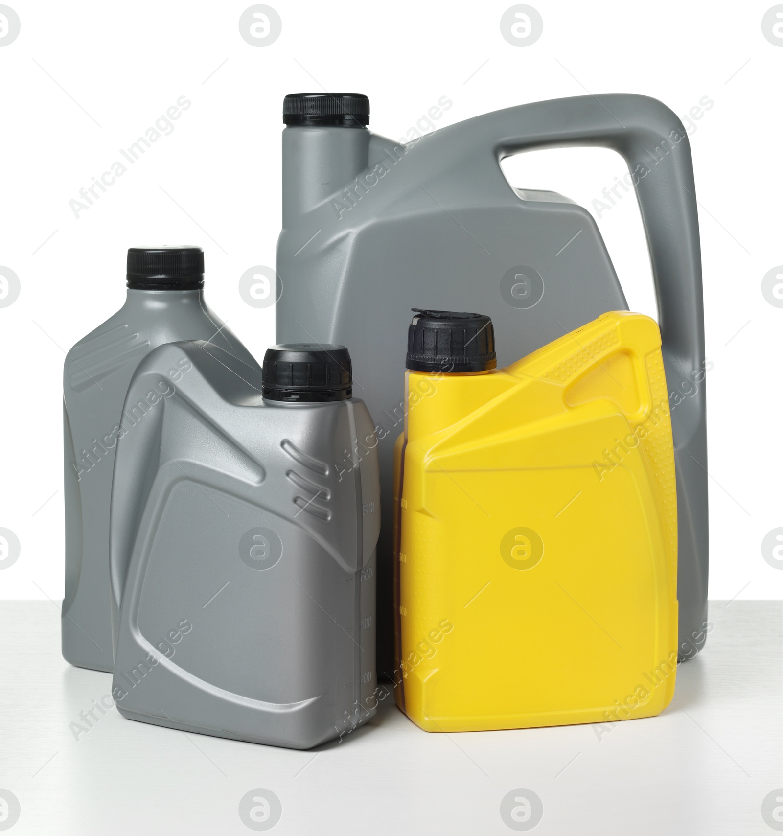 Motor oil in plastic canisters isolated on white Photo of Motor oil in plastic canisters isolated on white