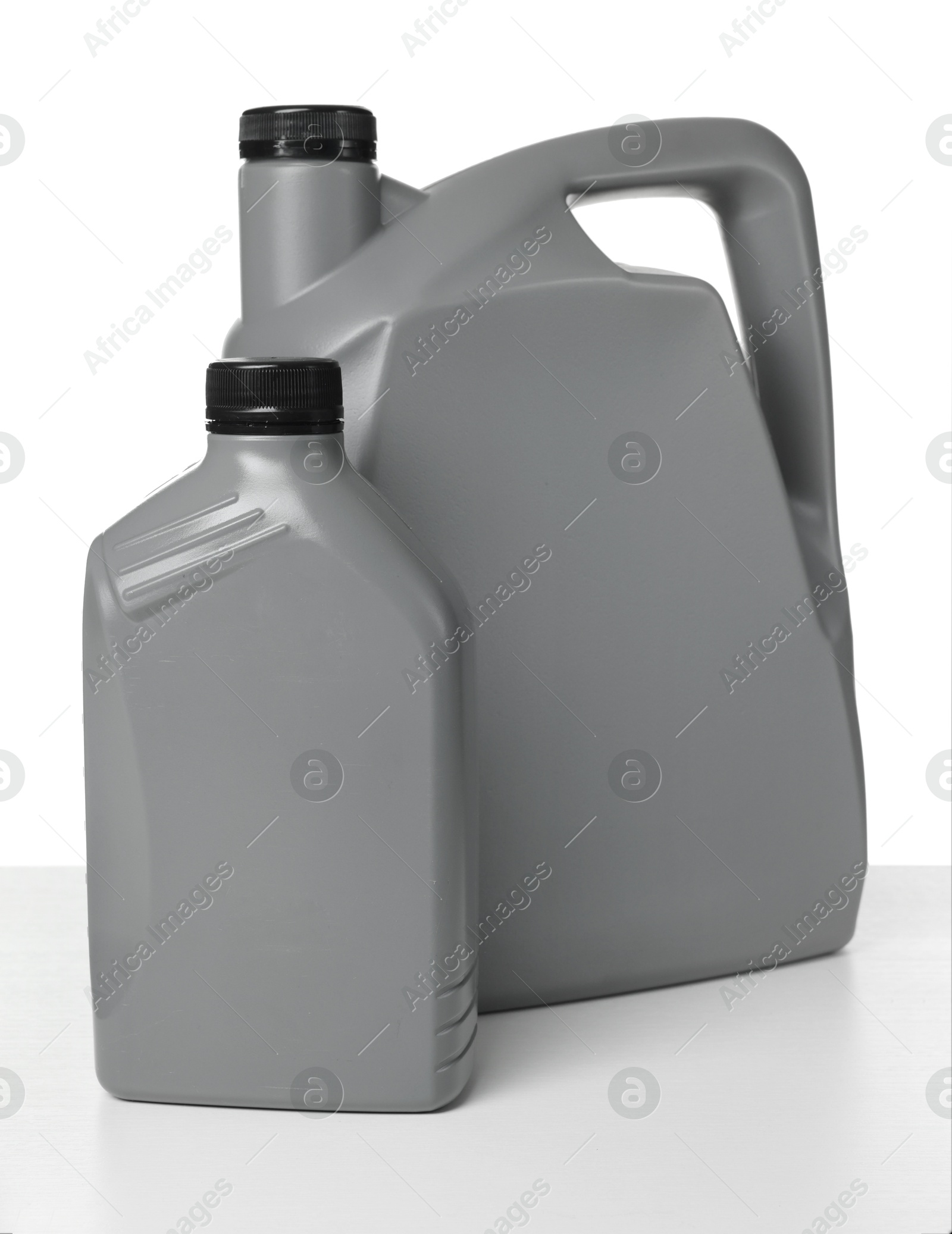 Motor oil in plastic canisters isolated on white Photo of Motor oil in plastic canisters isolated on white