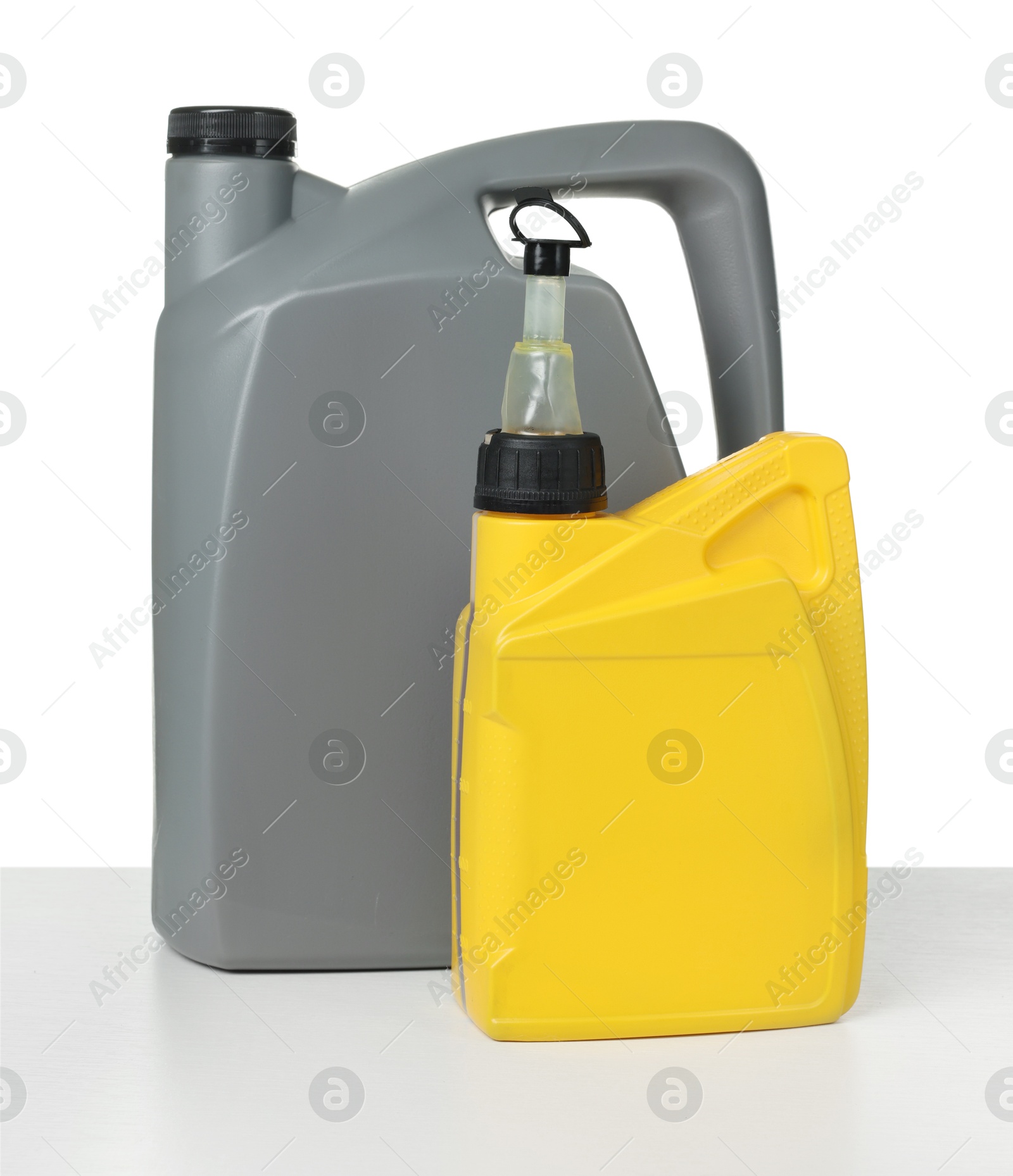 Motor oil in plastic canisters isolated on white Photo of Motor oil in plastic canisters isolated on white