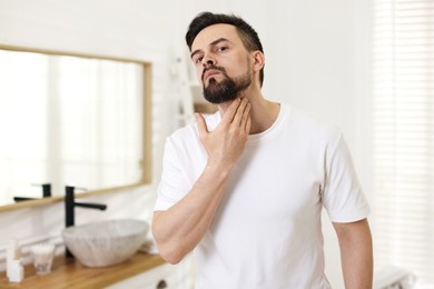 Photo of Portrait of handsome man before shaving in bathroom