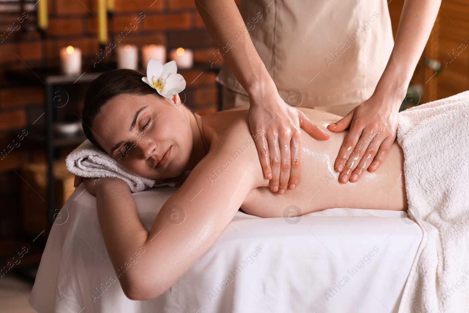 Woman receiving back massage with oil in spa salon Photo of Woman receiving back massage with oil in spa salon