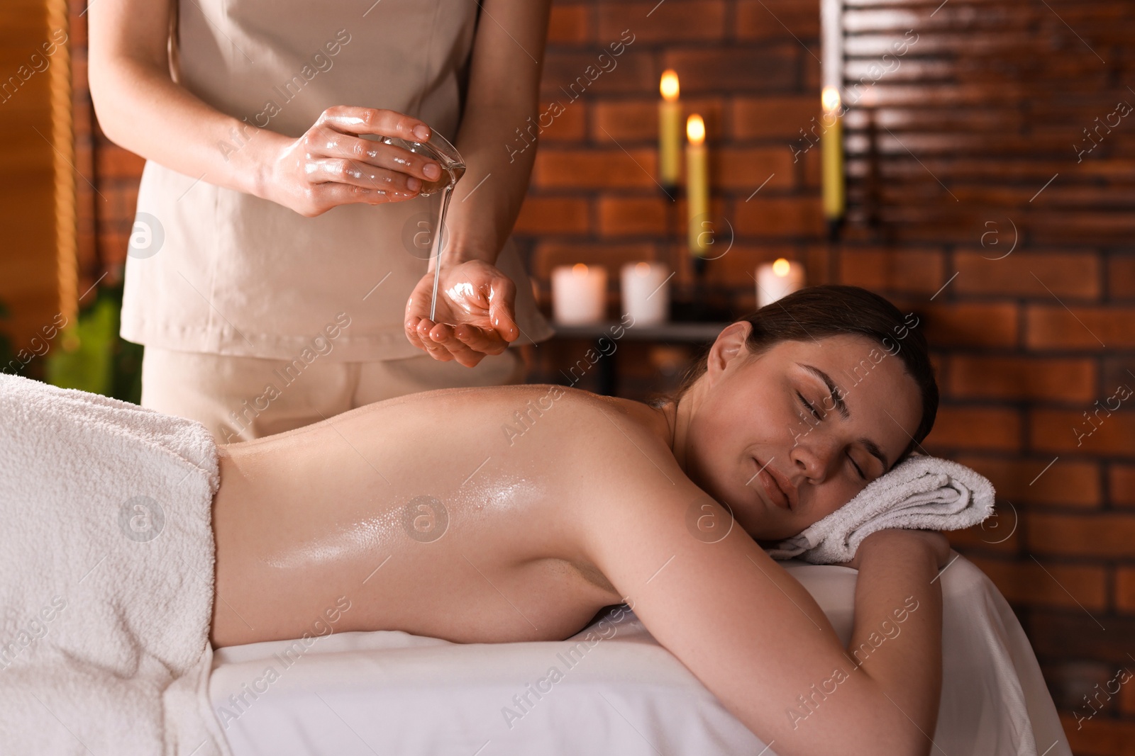 Photo of Woman receiving back massage with oil in spa salon