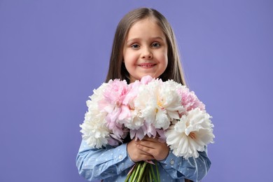 Photo of Cute little girl with bouquet of beautiful peonies on purple background