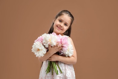 Photo of Cute little girl with bouquet of beautiful peonies on brown background