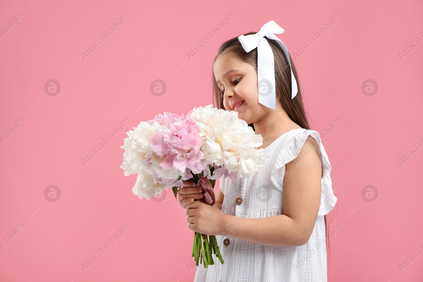 Cute little girl with bouquet of beautiful peonies on pink background Photo of Cute little girl with bouquet of beautiful peonies on pink background