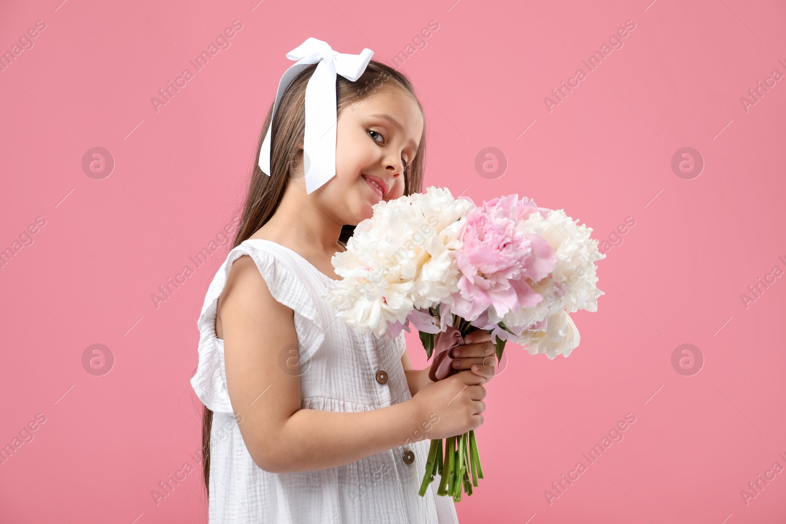 Cute little girl with bouquet of beautiful peonies on pink background Photo of Cute little girl with bouquet of beautiful peonies on pink background