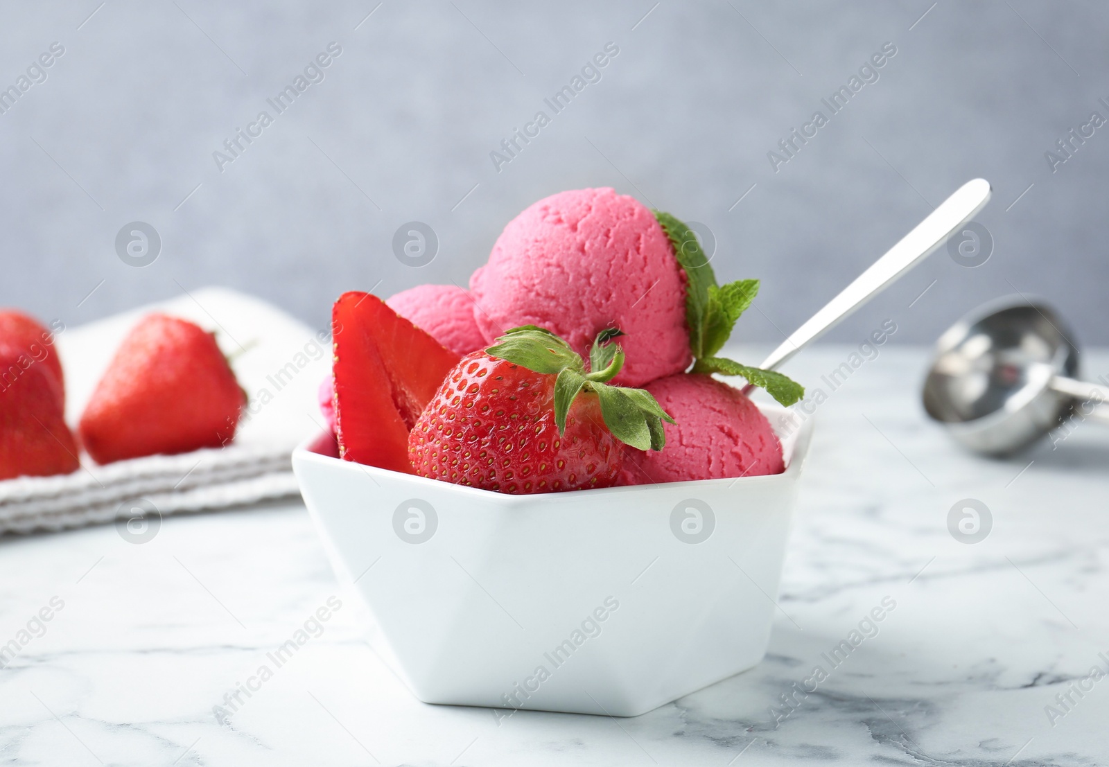 Refreshing sorbet, strawberries and mint in bowl on white marble table against grey background, closeup Photo of Refreshing sorbet, strawberries and mint in bowl on white marble table against grey background, closeup