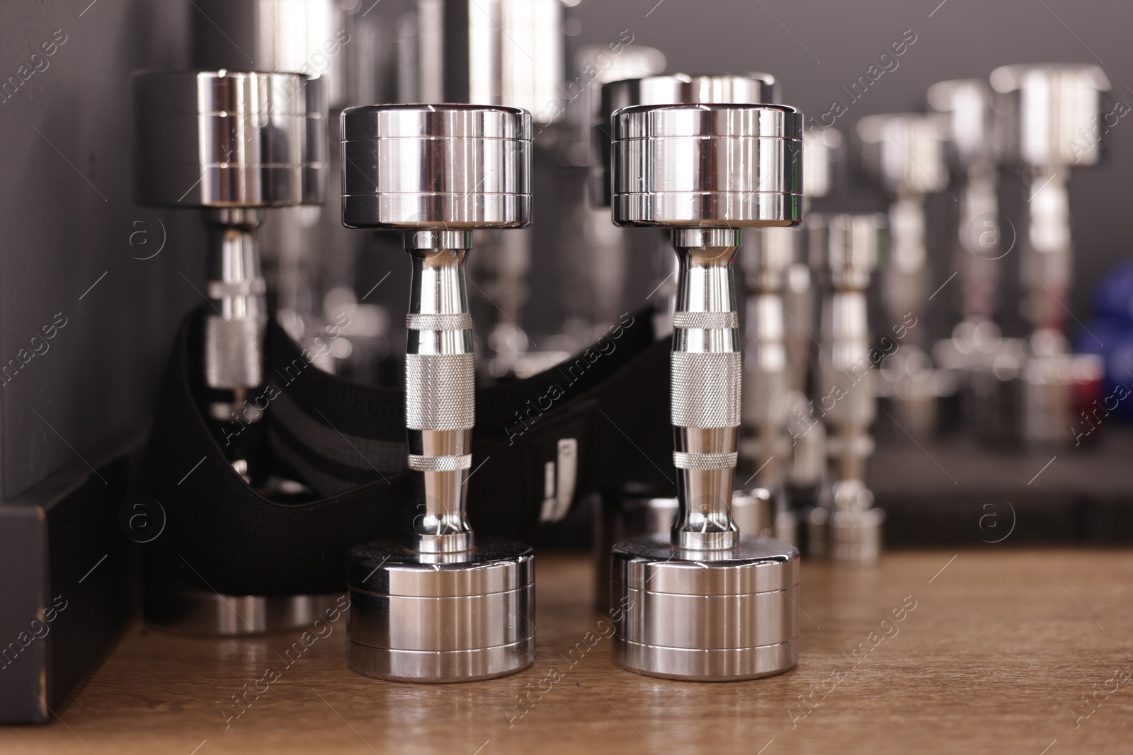 Many dumbbells on floor in fitness studio, closeup Photo of Many dumbbells on floor in fitness studio, closeup