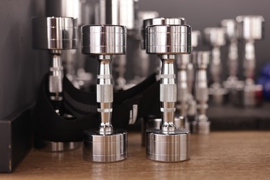 Photo of Many dumbbells on floor in fitness studio, closeup