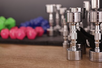 Photo of Many dumbbells on floor in fitness studio, closeup. Space for text