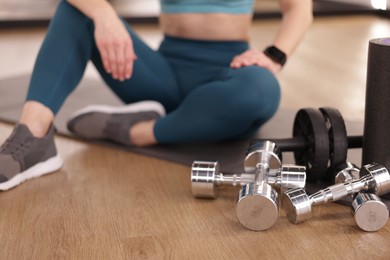 Photo of Woman with different sports equipment in fitness studio, closeup