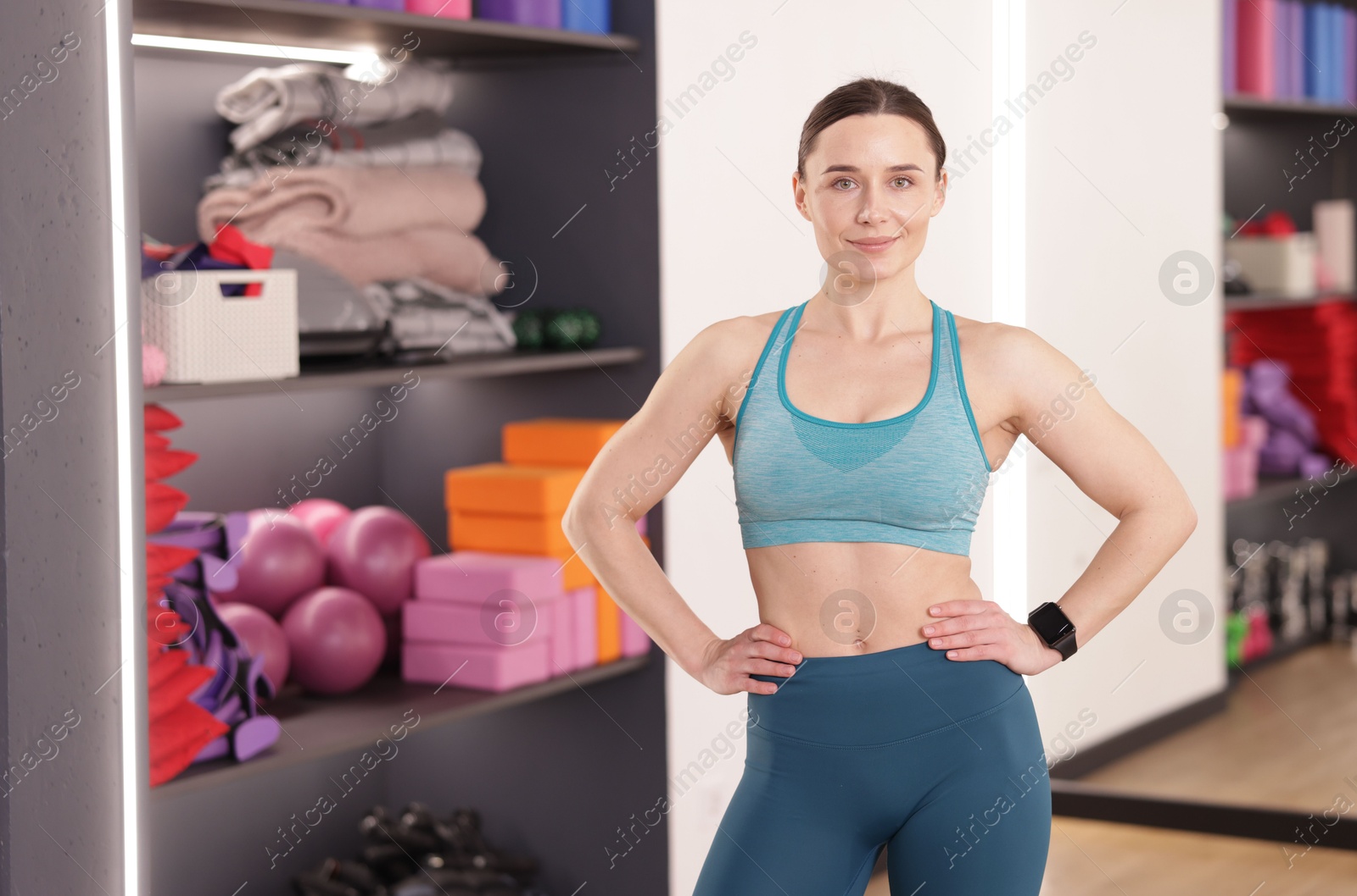 Photo of Beautiful woman wearing sportswear in fitness studio, space for text