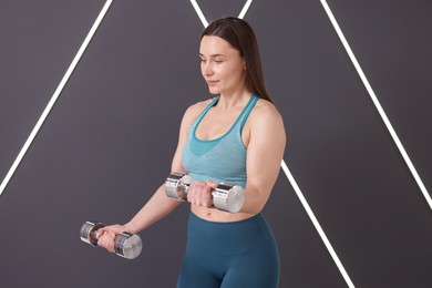 Photo of Woman exercising with dumbbells in fitness studio