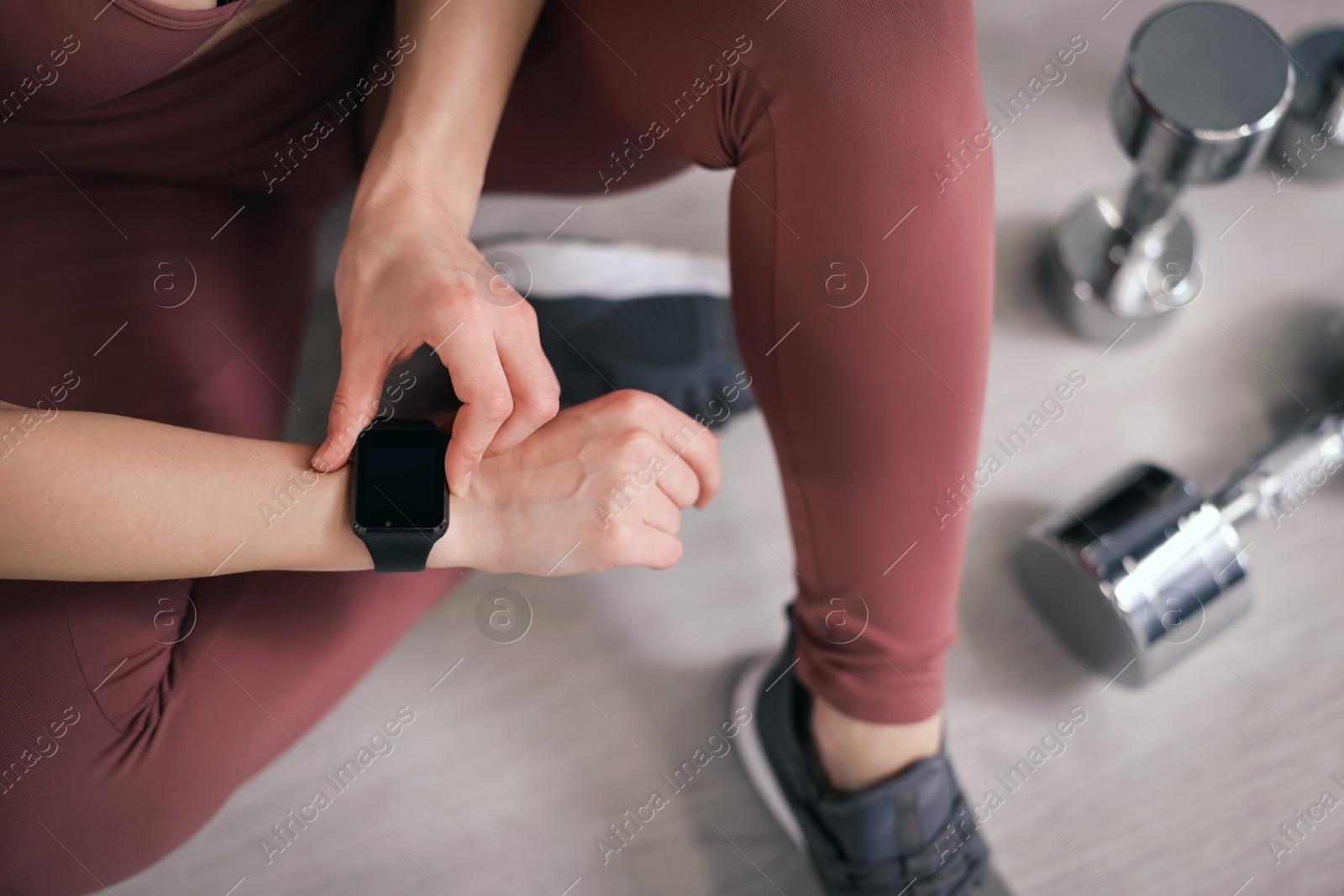 Woman checking fitness tracker during training indoors, above view Photo of Woman checking fitness tracker during training indoors, above view
