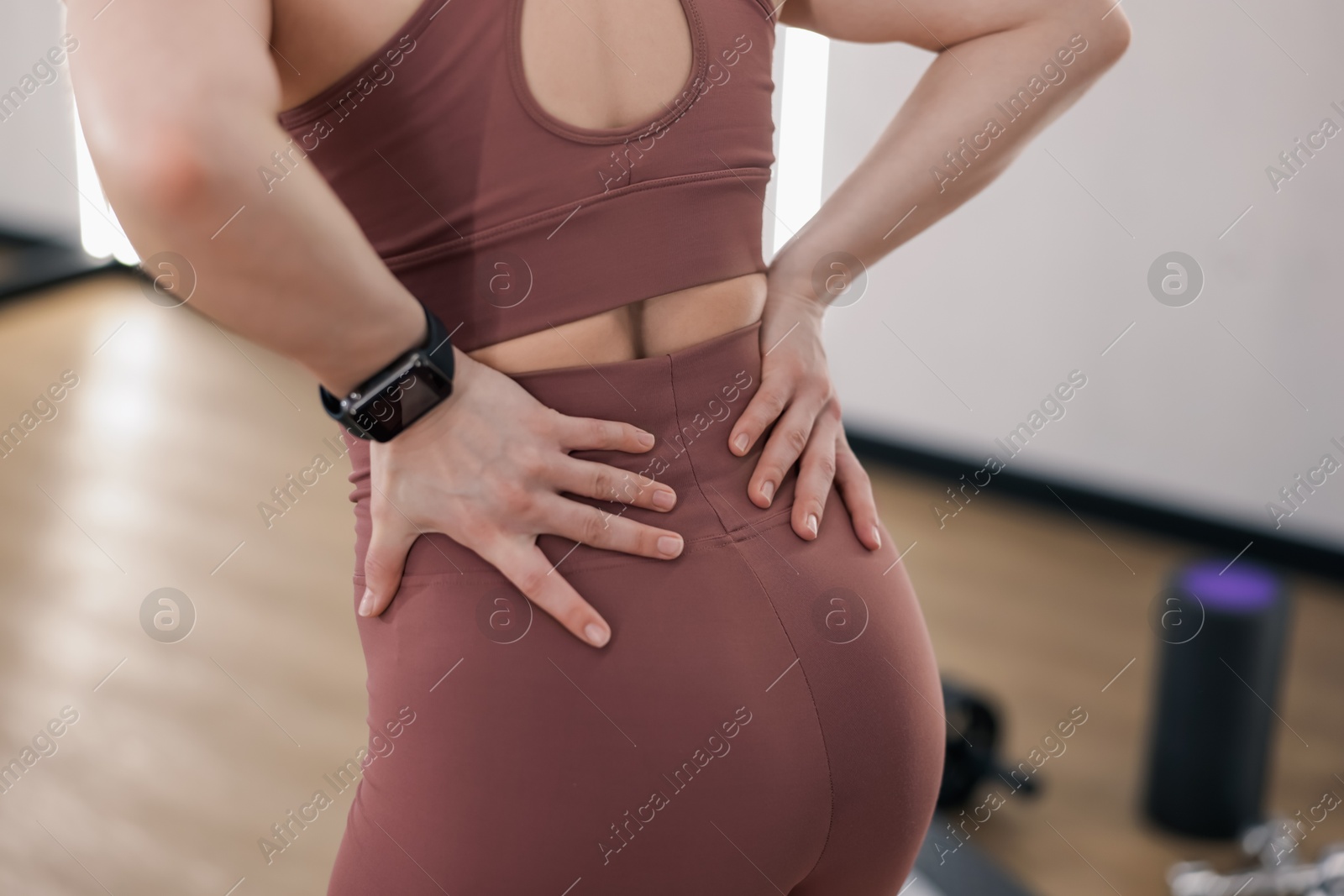 Sportswoman with back injury in fitness studio, closeup Photo of Sportswoman with back injury in fitness studio, closeup