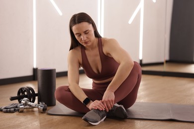 Photo of Sportswoman with leg injury in fitness studio
