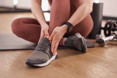 Photo of Sportswoman with leg injury in fitness studio, closeup