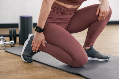 Photo of Sportswoman with leg injury in fitness studio, closeup