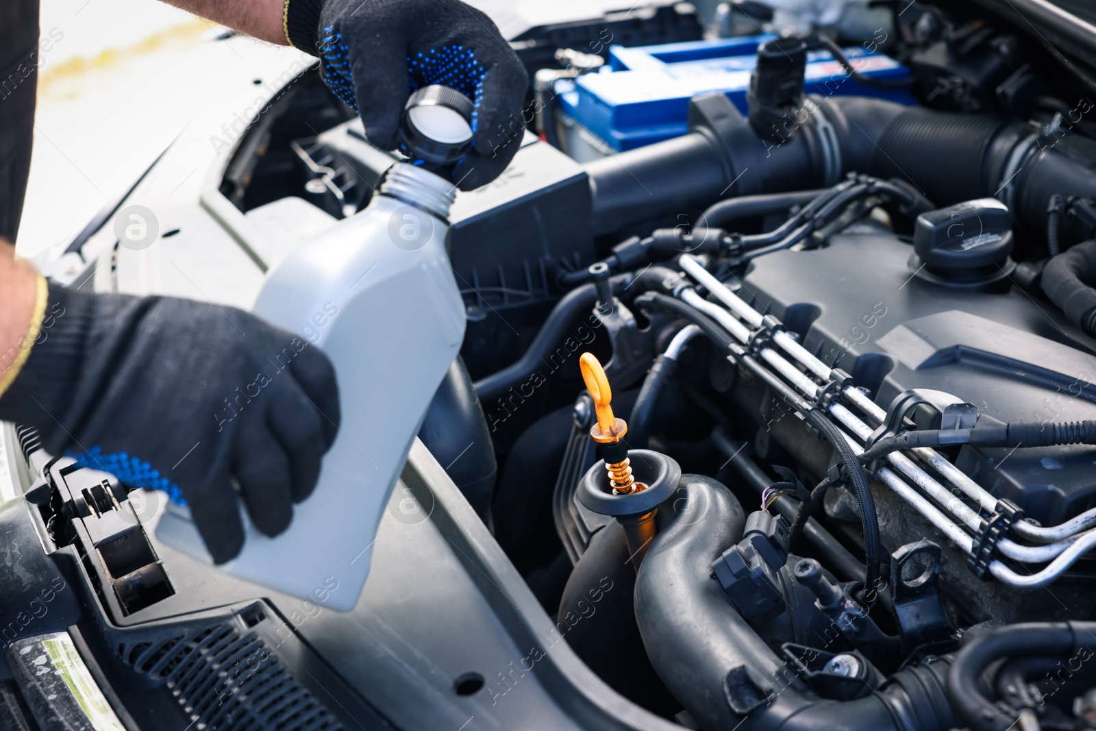 Worker checking motor oil level in car with dipstick, closeup Photo of Worker checking motor oil level in car with dipstick, closeup