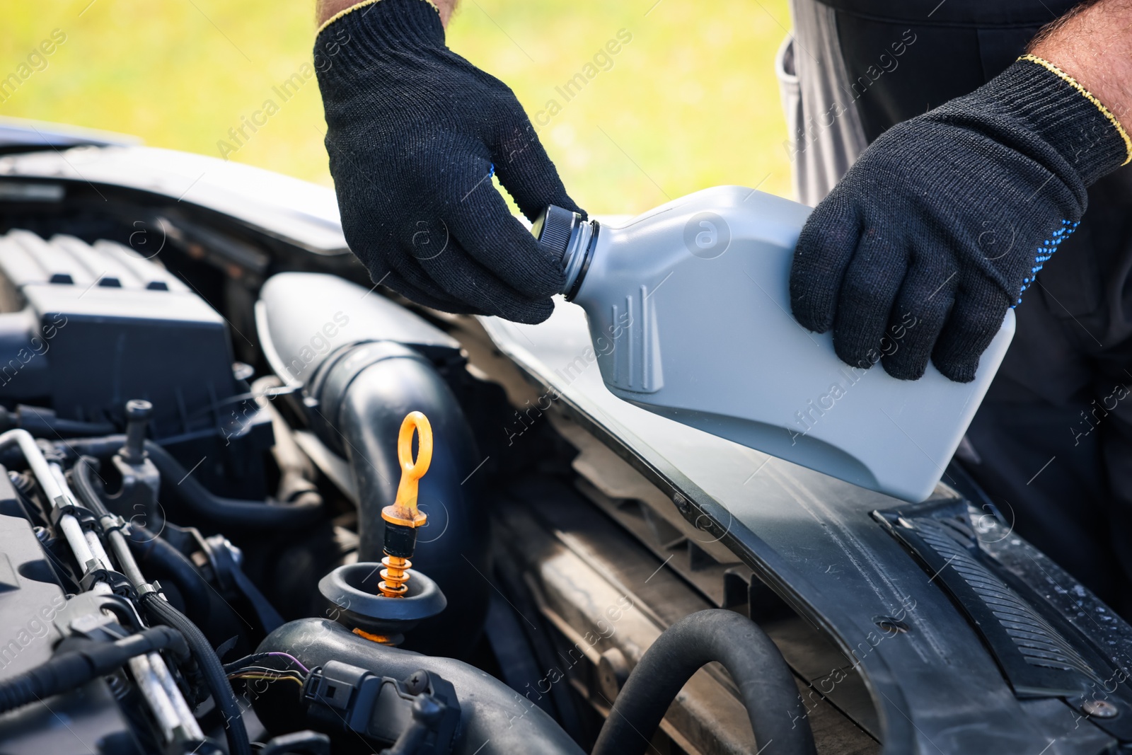 Worker checking motor oil level in car with dipstick, closeup Photo of Worker checking motor oil level in car with dipstick, closeup