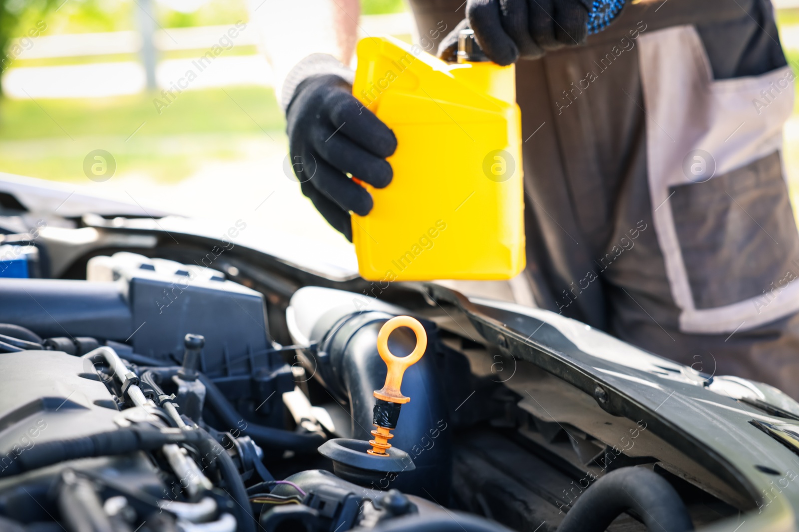 Worker checking motor oil level in car with dipstick, closeup Photo of Worker checking motor oil level in car with dipstick, closeup