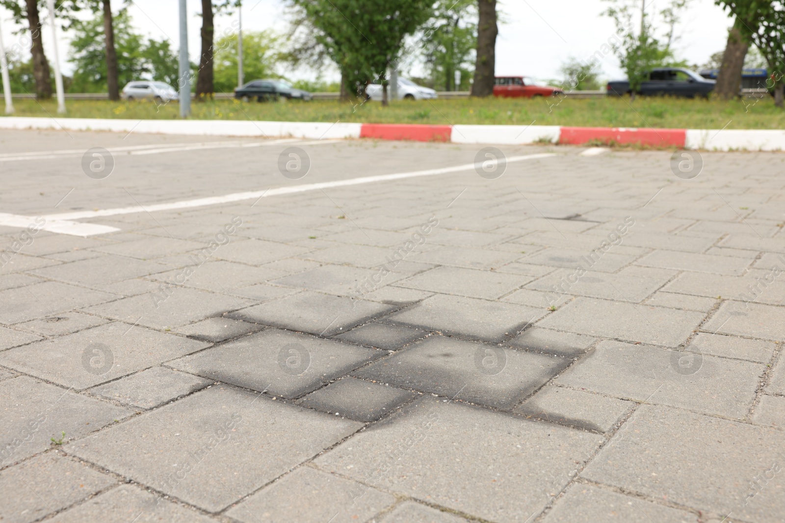 Stains of motor oil on road outdoors, closeup Photo of Stains of motor oil on road outdoors, closeup