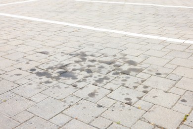 Photo of Stains of motor oil on road outdoors, closeup